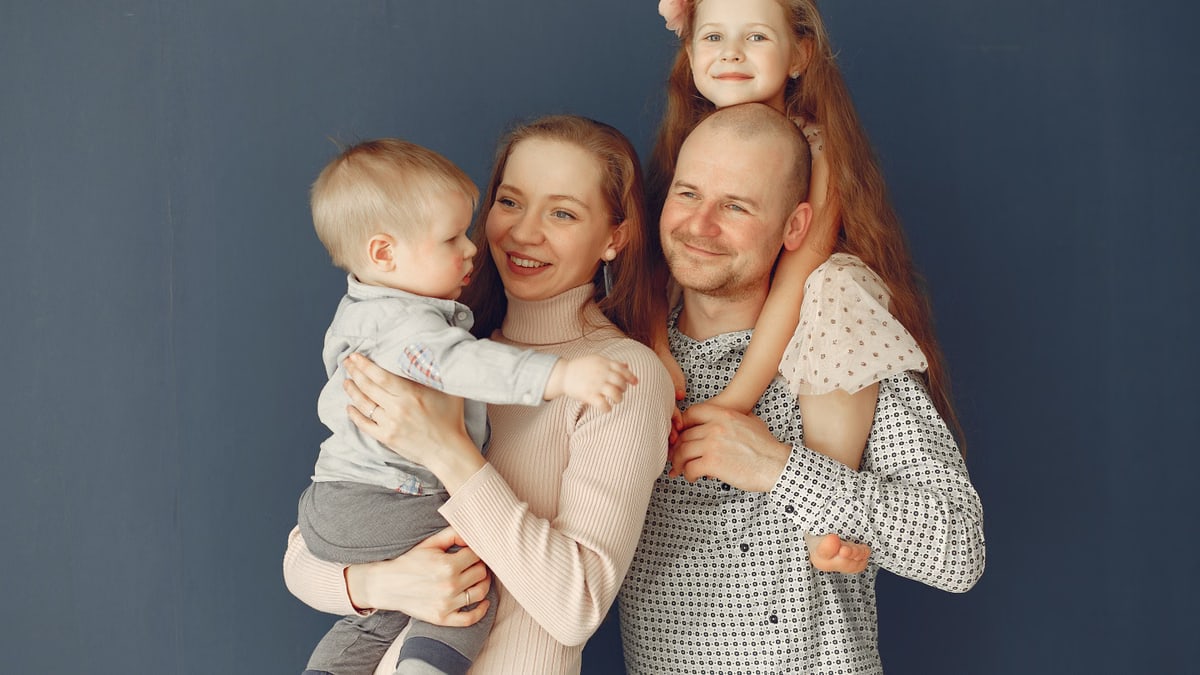 A joyful family portrait showcasing parents and their two children, expressing love and togetherness.
